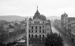 Szlovákia, Kassa, Fő tér (Hlavné namestie), szemben az Állami Színház, jobbra a Szentháromság-templom. Előtérben a csehszlovák köztársasági emlékoszlop látható., 1938, Fortepan, Csehszlovákia, nemzeti színház, színház, obeliszk, Láng Adolf-terv, utcai lámpa, neobarokk stílus, Fortepan #28483