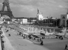 Franciaország, Párizs, Világkiállítás 1937., Trocadéro-kert. Balra az Eiffel-torony, ettől jobbra a szovjet pavilon előtt Vera Muhina "Munkás és kolhozparasztnő" ("Rabocsij i kolhoznyica") című szobra. Ezt a szobrot a világkiállítás vége után a Szovjetunióba szállították és Moszkvában állították fel, mind a mai napig ott is áll. A kép jobb szélén Románia pavilonja., 1937, Gara Andor, Fortepan #285337