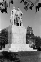 Magyarország, Budapest VIII., II. János Pál pápa (Köztársaság) tér, a Nemzeti munka szobra (Siklódy Lőrinc, 1943.). Háttérben a Fiumei úti Baleseti Intézet és az OTI székház tornya., 1960, Gara Andor, szobor, szoborcsoport, Budapest, Fortepan #285511