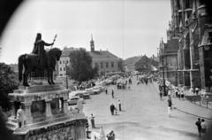 Magyarország, budai Vár, Budapest I., Szentháromság tér, kilátás a Halászbástyáról Szent István szobra (Stróbl Alajos, 1906.) és a Mátyás-templom felé. Szemben a Tárnok utca - Szentháromság utca sarkán a régi budai Városháza épülete., 1965, Szilvási hagyaték, Budapest, Fortepan #287093