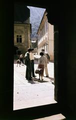 Romania,Transylvania, Brașov, Honterus-udvar (Curtea Honterus), a Fekete templom oldalsó bejáratán keresztül készült fényképezve, szemben a Strada Hans Benkner., 1956, Csaba László örökösei, colorful, talks, pedestrian, Fortepan #287910