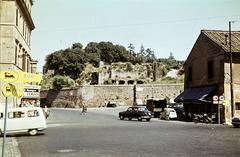 Olaszország, Róma, Via dei Cerchi, szemben a Via di San Teodoro, a Parco archeologico del Colosseo kőfala mögöt a Fortezze dei Frangipane romjai., 1960, Csaba László örökösei, Fiat 1400, színes, Fortepan #287937