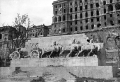 Magyarország, Budapest I., Dózsa György (Palota) tér, Ligeti Miklós alkotása (1937), a Lovas tüzérek hősi emlékműve (később Dózsa György szobra került a helyére). Mögötte a romos Királyi Palota (később Budavári Palota)., 1945, Military Museum of Southern New England, emlékmű, rom, Budapest, háborús kár, épületkár, Fortepan #30885