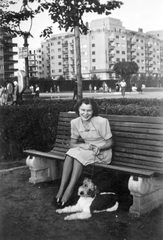 Hungary, Budapest XIII., Szent István park, háttérben a 26. sz. ház (Pozsonyi út sarok)., 1939, Várkonyi Benedek, portrait, dog, street view, lamp post, bench, lady, jewelry, Budapest, summer dresses, walking the dog, leash, fox terrier, Fortepan #31467