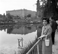 Magyarország, Budapest XI., Feneketlen-tó, háttérben a Villányi út, a Szent Imre-templom és a József Attila (később Budai Ciszterci Szent Imre) Gimnázium., 1963, Beyer Norbert, divat, templom, tó, víztükör, gimnázium, táska, tükröződés, kosztüm, Budapest, ciszterci rend, neobarokk stílus, Wälder Gyula-terv, Fortepan #31684