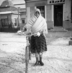 Szlovákia, Losonc, "A losonci mezőgazdasági szövetkezet terményraktára" és Bata cipőbolt., 1940, Fortepan, portré, kerékpár, tél, nő, cipőbolt, Bata-márka, Fortepan #32012