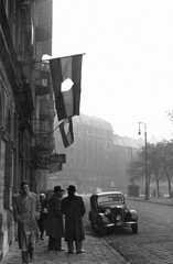 Magyarország, Budapest VIII., II. János Pál pápa (Köztársaság) tér a Vay Ádám utca felől a Népszínház utca felé nézve., 1956, Pesti Srác2, zászló, német gyártmány, forradalom, utcakép, életkép, Mercedes-márka, lámpaoszlop, automobil, Mercedes W136, cipész, szabóság, jelkép, Budapest, lyukas zászló, Fortepan #32773