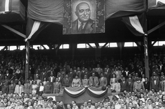 Magyarország, Budapest IV., Újpest, Megyeri út, UTE pálya, Magyarország - Olaszország (1:1) válogatott labdarúgó-mérkőzés. A díszpáholyban balról Dobi István, Szakasits Árpádné, Szakasits Árpád, Gerő Ernő, Marosán György, a második sorban Farkas Mihály, Kádár János, a negyedik Ries István, Marosán mögött Hegyi Gyula, a harmadik sorban bal szélen Kállai Gyula. Dobi Istvántól balra, egy sorral lejjebb Ortutay Gyula és Péter Gábor. És fenn díszkeretben egy hatalmas Rákosi kép., 1949, Kovács Márton Ernő, politikai dekoráció, Rákosi Mátyás-ábrázolás, Budapest, híres ember, politikus, Fortepan #33169