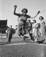 Magyarország, Budapest IX., Üllői út, FTC stadion. MHK próba élsportolóknak. Novák Éva ugrik, a homok mellett Novák Ilona nézi, mindketten későbbi olimpiai bajnok úszók., 1949, Kovács Márton Ernő, távolugrás, MHK Mozgalom, Budapest, nők, Fortepan #33202