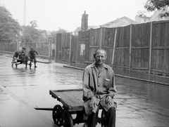 Magyarország, Budapest VIII., Tömő utca az Illés (Romanelli) utca felé nézve, háttérben a Füvészkert., 1935, Homoródy Károly, portré, utcakép, életkép, léckerítés, férfi, kézikocsi, munkaköpeny, Budapest, Fortepan #3483