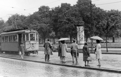 Magyarország, Budapest VIII., Üllői út, Ludovika (Kun Béla) tér., 1960, Fortepan, plakát, utcakép, villamos, hirdetőoszlop, esernyő, orkánkabát, villamosmegálló, viszonylattábla, Budapest, Fortepan #385