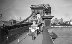 Hungary, Budapest I., a Széchenyi Lánchíd budai hídfője, a túlparton a Magyar Tudományos Akadémia és a mai Belügyminisztérium épülete., 1936, Ted Grauthoff, bridge, sculpture, Renaissance Revival, lion, Danube, board, Hungarian Academy of Sciences, stone lion, Budapest, suspension bridge, William Tierney Clark-design, Friedrich August Stüler-design, Fortepan #39254