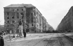 Magyarország, Budapest VIII.,Budapest IX., Üllői út - Nagykörút kereszteződés, Üllői út a Nagyvárad tér felé nézve, balra a Corvin (Kisfaludy) köz., 1956, Nagy Gyula, háborús kár, plakát, szovjet gyártmány, forradalom, hirdetőoszlop, járműroncs, harcjármű, ISZU-152 rohamlöveg, Budapest, épületkár, Fortepan #39805