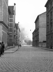 Magyarország, Budapest VIII., Bezerédj utca a Kiss József utcából a II. János Pál pápa (Köztársaság) tér felé nézve., 1956, Nagy Gyula, forradalom, utcakép, kockakő, füst, Budapest, Fortepan #39895