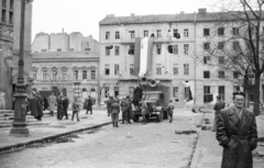 Magyarország, Budapest VIII., II. János Pál pápa (Köztársaság) tér, MDP Budapesti Pártbizottságának székháza az Erkel színház mellől nézve., 1956, Nagy Gyula, háborús kár, plakát, zászló, forradalom, magyar gyártmány, járókelő, teherautó, Csepel-márka, hirdetőoszlop, katona, épületkár, Csepel B-350/D-350, hangosbeszélô, Budapest, Fortepan #39920