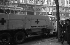 Magyarország, Budapest V., Szabad sajtó út, háttérben a Párizsi udvar. A Nemzetközi Vöröskereszt élelmiszersegélyét szállító teherautó., 1956, Nagy Gyula, felirat, forradalom, járókelő, teherautó, utcakép, segítség, vöröskereszt, középület, eklektikus építészet, Budapest, Henrik Schmahl-terv, Fortepan #39961