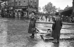 Magyarország, Budapest VI., Nyugati (Marx) tér, Westend-ház., 1956, Nagy Gyula, egyenruha, cégtábla, forradalom, fegyver, esőkabát, pályaudvar, csibilámpa, karszalag, eső, puska, Budapest, Gustave Eiffel-terv, Fortepan #40230