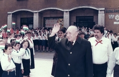 Hungary, Budapest XIII., Fiastyúk (Thälmann) utca 47-49., Kádár János látogatása a 2 sz. Általános Iskolában (később Hegedűs Géza Általános Iskola), mögötte bőrkabátban Deák Gábor kerületi párttitkár., 1985, Angyalföldi Helytörténeti Gyűjtemény, celebrity, school, pioneer, colorful, political decoration, 1st of May parade, Little drummer, leather jacket, Budapest, politician, Fortepan #41324