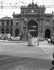 Svájc, Zürich, Főpályaudvar, előtte Alfred Escher szobra., 1966, Bettina Fabos, forgalom, cégtábla, óra, szobor, utcakép, életkép, neoreneszánsz, pályaudvar, Swissair légitársaság, sínpálya, felsővezeték, Alfred Escher-ábrázolás, Richard Kissling-terv, Jakob Friedrich Wanner-terv, gyalogátkelő, Fortepan #41367