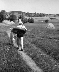 Magyarország, Sukoró, látkép a Velencei-tó felől, balra a református templom tornya, jobbra a katolikus templom látszik., 1954, Csermely Károly, magány, kalap, fürdőruha, úszógumi, strandcikkek, mező, nyár, látkép, domboldal, kazal, rét, Fortepan #41656