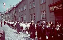 Magyarország, Győr, Káptalandomb, Szent László napi körmenet a Gutenberg tér felől nézve., 1939, Konok Tamás id, kalap, iskola, színes, egyenruha, zászló, cégtábla, oktatás, utcakép, lányiskola, felvonulás, diáksapka, Fortepan #42688