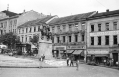 Magyarország, Pécs, Széchenyi tér, Hunyadi János szobra., 1957, Fortepan, cégtábla, szobor, utcakép, életkép, könyvesbolt, telefonfülke, vörös csillag, újságárus, kézikocsi, Hunyadi János-ábrázolás, Fortepan #44049