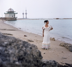 Kuvait, Kuvaitváros, a Kuvaiti-öböl partja, háttérben a Kuwait Towers (víztornyok). Csató Mari manöken., 1973, Schiffer Pál, divat, színes, nyaklánc, torony, hölgy, tengerpart, manöken, fülbevaló, karkötő, nyári ruha, konty, maxi ruha, platform cipő, divatfotózás, Fortepan #44736