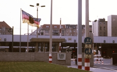 Németország, Berlin, Friedrichstrasse. Határátkelőhely Nyugat-Berlin és Kelet-Berlin között a nyugati oldalról, a Zimmerstrasse felől nézve., 1988, Urbán Tamás, színes, zászló, NDK, határállomás, Kelet-Berlin, Nyugat-Berlin, többnyelvű felirat, Fortepan #44764