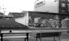 Németország, Berlin, Zimmerstrasse. Nyugat-Berlin és Kelet-Berlin közötti határátkelőhely a Friedrichstrasse-n, a nyugati oldalról nézve. Előtérben a berlini fal., 1988, Urbán Tamás, reklám, NDK, lámpaoszlop, határállomás, pad, graffiti, Berlini fal, Kelet-Berlin, Nyugat-Berlin, Fortepan #44780