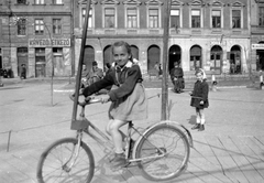 Magyarország, Budapest VI., Hunyadi tér, szemben a 9-es számú ház., 1949, Fortepan, kerékpár, cégtábla, fodrászat, kávézó, Budapest, kislány, masni, tanulás, körhinta, Fortepan #4564