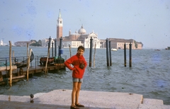 Olaszország, Velence, szemben a San Giorgio Maggiore sziget és a San Giorgio Maggiore-templom, a Szent Márk tér előtti partról nézve., 1966, Gwen Jones, portré, színes, csónak, látkép, fényképezőgép, stég, vízpart, sziget, gondola, csípőre tett kéz, Fortepan #46902