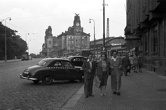 Czech Republik, Prague, Wilsonova ulice, szemben a főpályaudvar. Az előtérben Skoda 1200-as személygépkocsi., 1956, Nagy Gyula, Czechoslovakia, sign-board, Czechoslovak brand, watch, tableau, men, commercial vehicle, street view, genre painting, Skoda-brand, taxicab, Secession, shades, lamp post, woman, train station, cobblestones, taxicab stand, church clock, Art Nouveau architecture, Josef Fanta-design, Fortepan #51391