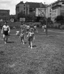 Magyarország, Budapest XI., Kőrösy József (Mező) utca, BEAC-pálya. Háttérben a Váli utcai iskola (később József Attila Gimnázium) és a Közgazdasági Technikum (később Fényes Elek Közgazdasági Szakközépiskola)., 1959, Fortepan, Budapest, félmeztelen, Fortepan #52876