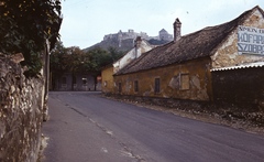 Magyarország, Sümeg, Széchenyi György utca a Kossuth Lajos utca felé nézve, háttérben a vár., 1977, Balázs Lajos, reklám, színes, felirat, utcakép, Fortepan #53317