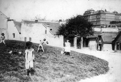 Magyarország, Tabán, Budapest I., Kereszt tér, balra a Holdvilág utca, jobbra az Aranykacsa utca torkolata, háttérben a Királyi Palota (később Budavári Palota)., 1914, Szabó Lóránt, kalap, gyerekek, játék, Budapest, Fortepan #53605