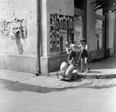 Slovakia, Fiľakovo, ulica Hlavná (Fő utca) - ulica Biskupická (Püspöki utca) sarok., 1959, Zsanda Zsolt, Vajszada Károly, Czechoslovakia, poster, boys, handbarrow, loaf of bread, Fortepan #53780