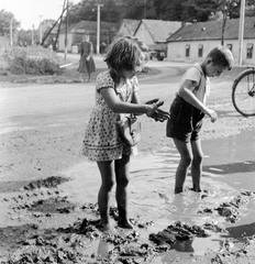 Slovakia, Fiľakovo, ulica Továrenská (Gyári utca), szemben az ulica Slovenského národného povstania (Szlovák Nemzeti Felkelés)., 1959, Zsanda Zsolt, Vajszada Károly, Czechoslovakia, puddle, kids, Fortepan #53788