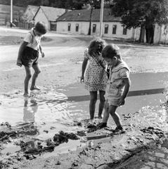 Slovakia, Fiľakovo, ulica Továrenská (Gyári utca), szemben az ulica Slovenského národného povstania (Szlovák Nemzeti Felkelés) eleje., 1959, Zsanda Zsolt, Vajszada Károly, Czechoslovakia, puddle, kids, Fortepan #53790