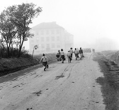 Szlovákia, Poltár, ulica Skolská (ekkor névtelen), balra az iskola., 1960, Zsanda Zsolt, Vajszada Károly, Csehszlovákia, iskola, buszmegálló, iskolatáska, köd, Fortepan #53986