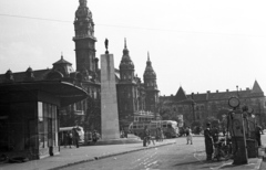 Magyarország, Győr, Szent István (Sztálin) út, benzinkút az IBUSZ pavilon előtt. Háttérben a szovjet emlékmű mögött a Baross Gábor (Lenin) út és a Városháza., 1958, Lencse Zoltán, kerékpár, autóbusz, motorkerékpár, magyar gyártmány, emlékmű, utcakép, életkép, Ikarus-márka, benzinkút, torony, Ikarus 30, szovjet emlékmű, neobarokk stílus, Hübner Jenő-terv, Fortepan #54531