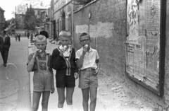 Magyarország, budai Vár, Budapest I., Szentháromság utca a Szentháromság tér felől nézve., 1958, Lencse Zoltán, plakát, csoportkép, utcakép, életkép, szemüveg, fagylalt, fiúk, Budapest, május 1, operaház, Fortepan #54539