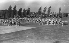 Magyarország, Budapest III., Seregély utca, az MMG (Mechanikai Mérőműszerek Gyára) sportpályája. Jobbra a távolban a margitszigeti víztorony látszik., 1958, Lencse Zoltán, torna, szél, Budapest, terpeszülés, Fortepan #54841