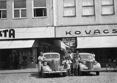 Ukrajna,Kárpátalja, Ungvár, Fencik Eugén (ekkor Szurmay) tér 1. és 3., szemben a Színházi köz., 1939, Párdányi Miklós, cégtábla, német gyártmány, Opel-márka, csoportkép, trafik, automobil, Opel Super 6, rendszám, Opel Olympia OL38, Fortepan #54930