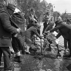 Magyarország, Budapest V., Széchenyi István (Ferenc József) tér. Háttérben a Pesti Magyar Kereskedelmi Bank épülete., 1939, Magyar Bálint, kalap, utcakép, életkép, lámpaoszlop, diáksapka, csatosüveg, borosüveg, vízcsap, Budapest, Fortepan #55539