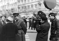 Magyarország, Budapest VII., Erzsébet (Lenin) körút - Dohány utca sarok, a háttérben a Híradó mozi. A Tv jelenti című aktuális riportműsor filmet forgat "Fernandel"-ről, a népszerű pesti rendőrről., 1967, Rádió és Televízió Újság, rendőr, sapka, mozi, operatőr, gumibot, Budapest, Fortepan #56477