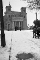 Magyarország, Vác, Schuszter Konstantin (Konstantin) tér, háttérben a Nagyboldogasszony-székesegyház., 1970, Piarista Levéltár/Holl Béla, tél, templom, hó, kutya, szánkó, lámpaoszlop, Isidore Canevale-terv, Fortepan #56932