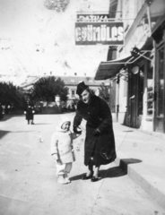 Hungary, Veszprém, Rákóczi Ferenc utca, a háttérben az Óváros (Rákóczi) tér. Fent a Fekete Sas patika cégtáblája látszik., 1935, Karabélyos Péter, sign-board, street view, fruit, woman, double portrait, kid, Fortepan #57406