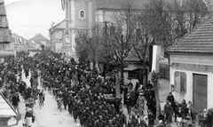 Szlovénia, Lendva, (Alsólendva), Fő utca. Jugoszlávia megszállása, a magyar csapatok bevonulása 1941. április 16-án., 1941, Karabélyos Péter, kerékpár, zászló, tömeg, lovaskocsi, felvonulás, üzletportál, ünnep, Fortepan #57467