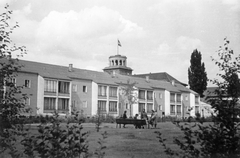 Németország, Berlin, a felvétel a Renatenweg környékén készült, háttérben az Ursulastraße és a Barbarastraße között az Auguste-Sprengel-Schule (ma Beethoven-Gymnasium) tornya látszik., 1942, Botár Angéla, épület, pad, zászlórúd, Fortepan #57898