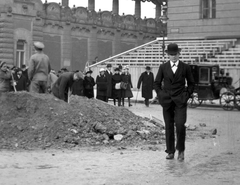 Hungary, Budapest I., Szent György tér a IV. Károly koronázásának idejére épített ideiglenes tribünnel. Balra a József főhercegi palota kerítése, jobbra a Honvédelmi Minisztérium., 1916, Németh Tamás, Urai Dezső, hat, street view, genre painting, worker, grandstand, bowler hat, fiacre, Budapest, hands in pockets, Fortepan #59073